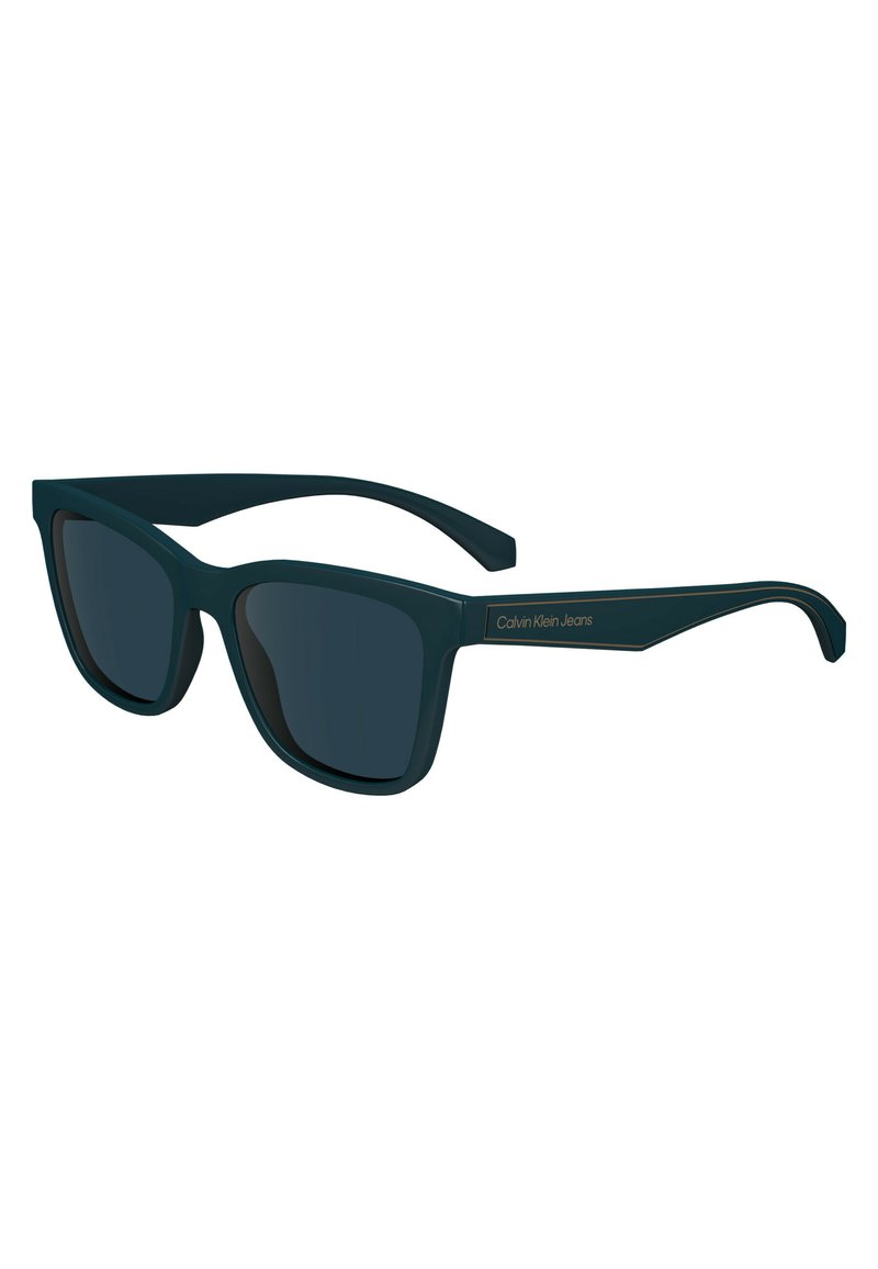 Occhiali da sole rettangolari color teal scuro con lenti scure. Presentano una montatura in plastica liscia e il logo dorato "Calvin Klein Jeans" sulla stanghetta.