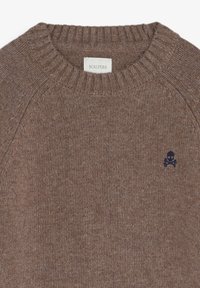 Jersey marrón de punto con cuello redondo acanalado y un emblema de calavera azul en el pecho. Textura suave y corte relajado. La etiqueta dice "SCALPERS."