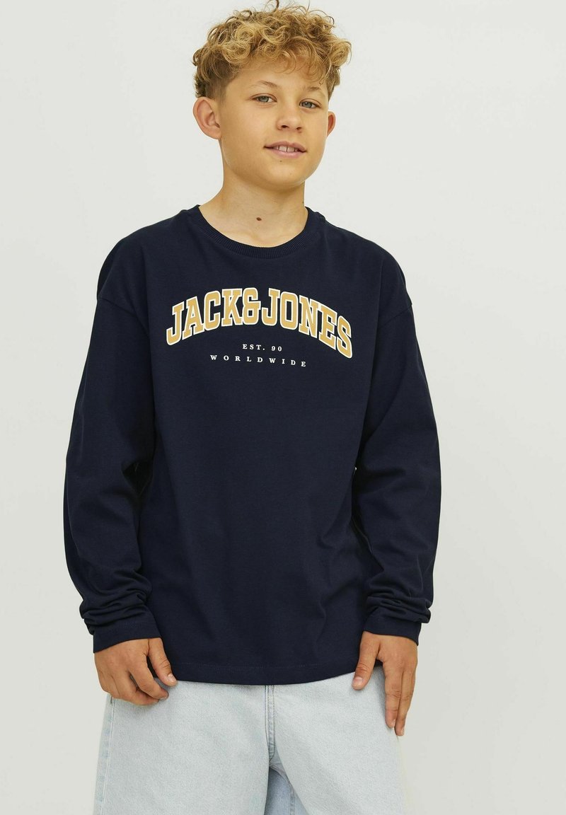 Pola plave dugih rukava majica ima bijeli i žuti dizajn s tekstom "JACK&JONES". Izrađena je od mekanog pamučnog materijala s opuštenim krojem i okruglim izrezom.