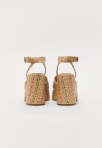 Woven platform sandals with a beige base, featuring colorful accents and a strap closure. Textured surface and block heel design.