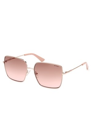 Ochelari de soare pătrați cu lentile gradient roz, ramă metalică roz aurie și brațe roz deschis. Prezintă numele brandului "GUESS" pe lateral.