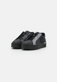 Czarne sneakersy z teksturowanym wykończeniem z brokatem. Posiadają srebrne akcenty brokatowe po bokach, okrągły czubek i grubą czarną podeszwę.