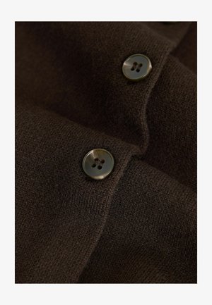 Brown fabric with a smooth texture, featuring two circular, dark buttons with four holes, partially overlapped.