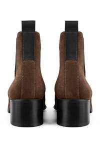 Stivaletti in suede marrone con pannelli laterali elasticizzati neri e un tacco voluminoso nero. Presenta dettagli di cuciture minime sul retro.