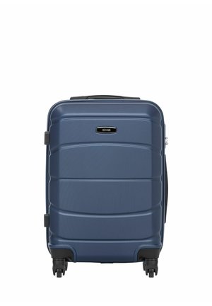 Ciemnoniebieska walizka z twardą powłoką, wyposażona w cztery czarne kółka i górny uchwyt, stojąca pionowo na białym tle.
