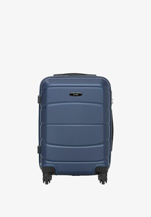 Ciemnoniebieska walizka z twardą powłoką, wyposażona w cztery czarne kółka i górny uchwyt, stojąca pionowo na białym tle.