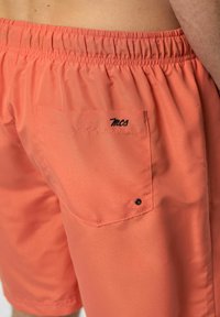 Oranžové plavkové šortky s elastickým pásom, zadnou vreckom a vyšívaným logom na vrecku. Hladká, ľahká tkanina.