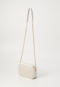 Borsa a tracolla bianca con forma rettangolare, texture liscia, tracolla in catena dorata e chiusura con zip superiore.