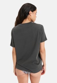 Mørkegrå bomulds T-shirt med en afslappet pasform, rund halsudskæring og korte ærmer, med et let drop tail-design bagpå.