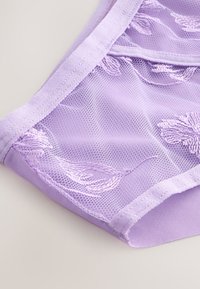 Modra modna mrežasta spodnja perila z vezenimi cvetličnimi vzorci. Mešanica mehkega blaga, prosojna tekstura in gladki elastični robovi.