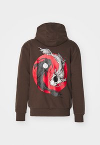 Felpa marrone con pesci koi bianchi e neri che formano un simbolo yin-yang su uno sfondo circolare rosso sul retro.