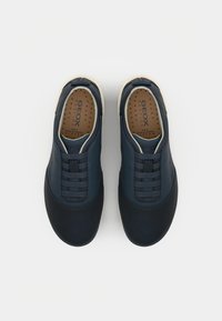 Marinefarbene Slipper aus glattem Lederobermaterial, mit elastischen Schnürsenkeln und einer hellen Sohle. Mit perforierter Innensohle für Atmungsaktivität.
