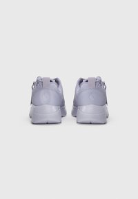 Un paio di sneakers viola chiaro viste da dietro, con linguette e logo in rilievo sul tallone, su uno sfondo bianco semplice.
