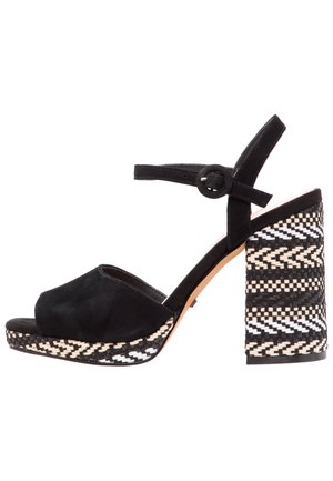 Sorte ruskindsandaler med åben tå og ankelrem. Har en mønstret sort-hvid vævet blokhæl. Glat tekstur, moderne design.