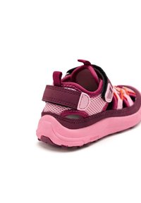 Zapatillas para niños en rosa y burdeos con material de malla, correa ajustable, suela texturizada y talón reforzado para mayor soporte.