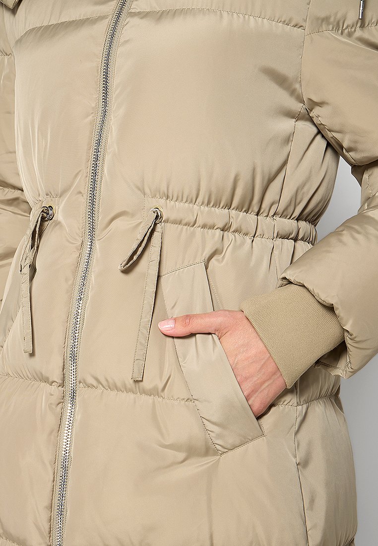 Doudoune beige avec fermeture éclair, taille à cordon et poignets en tricot. Caractéristiques d'un tissu lisse et brillant, ainsi que de poches latérales pour plus de fonctionnalité.