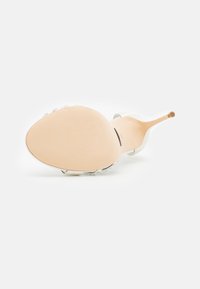 Sandały na przezroczystym obcasie z gładką kością słoniową cholewką, spiczastym noskiem i fakturowaną beżową podeszwą. Posiadają dekoracyjne akcenty z kryształków wokół paska.