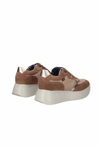 Sneaker in suede marrone con accenti metallici, suola platform bianca e fodera a motivo blu. Presenta un design con lacci e un branding sobrio.