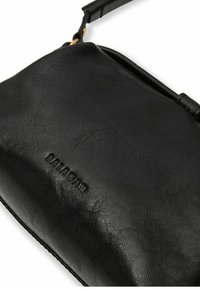 Borsa in pelle nera con una texture liscia, dotata di una cerniera superiore e logo "BALAGAN" in rilievo. Equipaggiata con una maniglia corta per il trasporto.