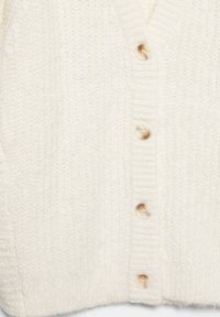 Krém színű kardigán V-nyakkal, texturált kötött anyagból, hat nagy gombbal. Bordázott mandzsetták és szegély, puha és kényelmes megjelenés.