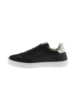 Zapatilla negra de caña baja con suela y talón blanco, cordones en la parte frontal y cuello acolchado, mostrada en perfil derecho sobre fondo blanco.