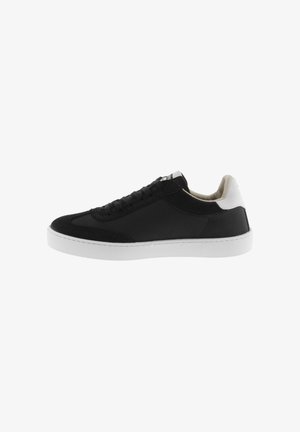 Zapatilla negra de caña baja con suela y talón blanco, cordones en la parte frontal y cuello acolchado, mostrada en perfil derecho sobre fondo blanco.