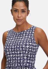 Marineblaues und weißes ärmelloses Kleid mit abstraktem geometrischen Muster. Glatte Textur mit taillierter Passform und leicht ausgestelltem Saum.