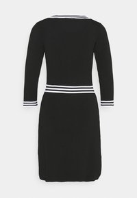 Robe noire à manches longues, col et poignets rayés en blanc. Taille ajustée avec un accent à rayures horizontales. Tissu tricoté doux et texturé.