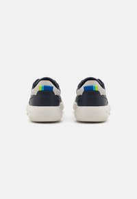 Sneaker blu navy con accenti in suede grigio, suola in gomma testurizzata e dettaglio del tallone in blu e verde a contrasto.