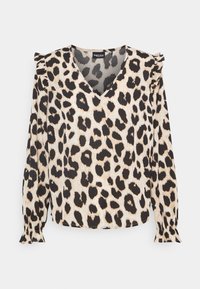 Blouse à imprimé léopard avec un col en V, des manches longues et des accents de volants aux épaules. Confectionnée en tissu doux beige avec des taches noires.
