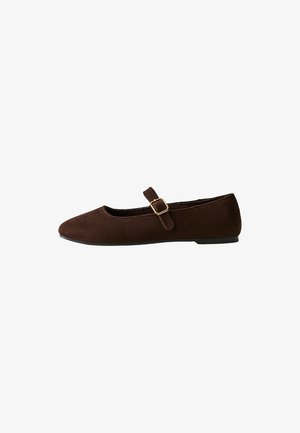 Chaussure plate Mary Jane en daim marron avec une bride à boucle dorée et une semelle noire, vue de côté sur fond blanc.
