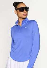 Μπλούζα με μακριά μανίκια και φερμουάρ σε βασιλικό μπλε, με ψηλό γιακά και λογότυπο Nike, με λεία υφή και εφαρμοστή γραμμή.