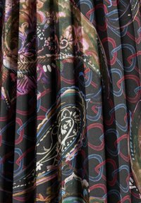 Zwarte stof met ingewikkelde meerkleurige bloem- en kettingpatronen, met een zachte textuur en geplooid ontwerp voor extra dimensie.