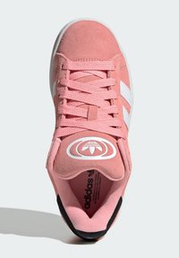 Rosa Wildledersneaker mit weißen Streifen, runder Spitze, strukturierten Schnürsenkeln und einem kreisförmigen Logo auf der Zunge. Schwarze Akzente an der Sohle.
