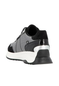 Chaussure de sport grise avec une tige texturée, des accents en daim, un talon noir brillant et une semelle intermédiaire blanche. Dispose de lacets et d'un col rembourré.