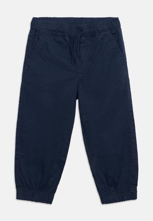 Pantalon bleu marine pour tout-petit avec taille élastique, cordon de serrage, poches latérales et poignets élastiqués aux chevilles.