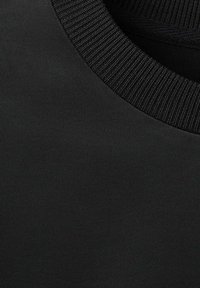 Czarna tkanina o gładkiej fakturze i prążkowanym kołnierzu. Wzór ma minimalistyczny styl, bez widocznych wzorów czy logo.