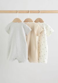 Trois grenouillères pour bébé à manches courtes suspendues sur des cintres en bois, avec des motifs d'étoiles, des rayures beige et de petites cerises noires.