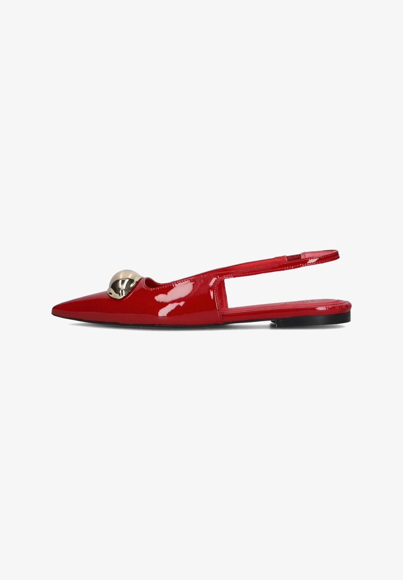 Red patent leather slingback shoes with a pointed toe, featuring a large gold circular accent on the upper. Flat sole, smooth texture.