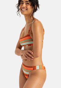 Randig bikiniuppsättning i orange, grön och brun, med en bralette-top med justerbara band och högmidjade bottnar med en mjuk textur.