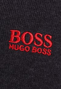 Strickmütze in Dunkelgrau mit roten, gestickten "BOSS"- und "HUGO BOSS"-Logos. Verfügt über ein strukturiertes, geripptes Design.
