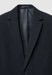 Marineblazer mit gekerbtem Revers, einer Tasche und einem glatten Satinfutter. Hergestellt aus strukturiertem Stoff, vorne mit zwei Knöpfen.