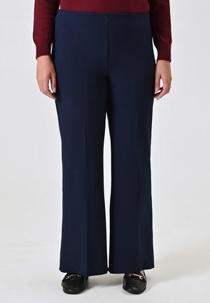 Pantaloni a vita alta di un blu navy, con un design a gamba svasata, realizzati in un tessuto liscio, senza motivi o decorazioni visibili.