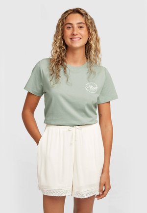 Lichtgroen katoenen T-shirt met korte mouwen en een ronde hals, gecombineerd met crèmekleurige geplooide shorts met kantafwerking en een taille met trekkoord.