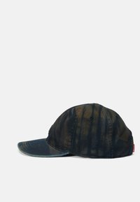 Baseball cap in dark blue and brown tie-dye pattern, made of cotton fabric, featuring a curved brim and adjustable strap at the back.