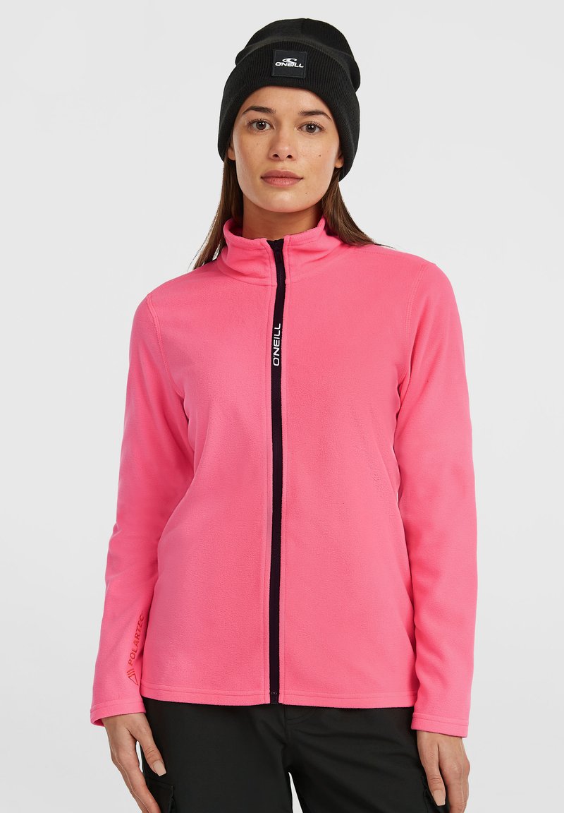 Fleece jaka spilgti rozā krāsā ar augstu apkakli, priekšējo rāvējslēdzēju un melniem akcentiem, kas satur nelielu logo. Garas piedurknes ar gludu tekstūru.