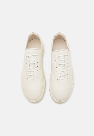 Weiße Lederturnschuhe mit glatter Oberfläche, Schnürverschluss und abgerundeten Zehen. Bieten ein minimalistisches Design und dezentes Branding auf der Innensohle.