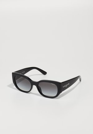 Óculos de sol retangulares pretos com lentes degradê, acabamento mate e bordas pronunciadas. Apresenta o logo "vogue" na haste.