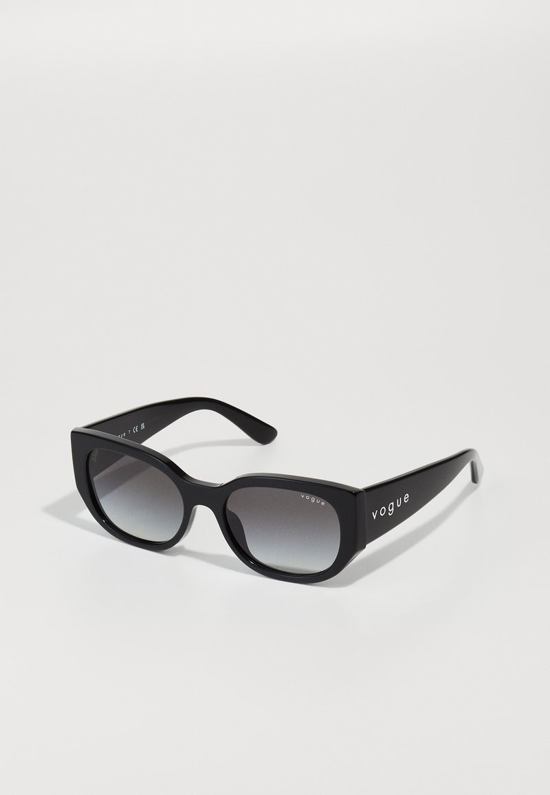 Black rectangular sunglasses with gradient lenses, matte finish, and pronounced edges. Features "vogue" logo on the temple.