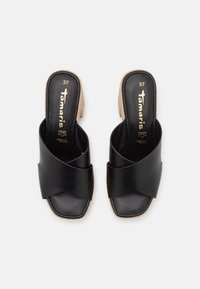 Sandalias deslizantes de cuero negro con tiras superiores cruzadas, punta cuadrada y suela de plataforma tejido beige. Talla 37. Marca dorada en la plantilla.